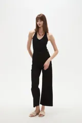 Pantalon tipo jean de corte flare y tiro alto, color verde oscuro, con cierre frontal y bolsillos.