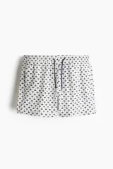 Short de baño de sirsaca con estampado de palmeras pequeñas, cintura elástica con cordón ajustable, bolsillos laterales y bolsillo trasero con cierre autoadherente. Presenta aberturas laterales en el ruedo y suspensor interior de malla.