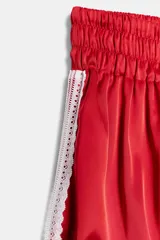 Shorts de tiro medio confeccionados en satén rojo, con diseño tipo globo y cintura elástica ajustable mediante cordones. Presentan detalles de encaje blanco en los laterales.
