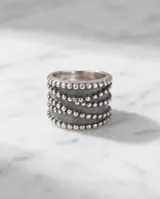 Anillo ancho de plata 925 con diseño de bandas texturizadas en bajo relieve y acabado empavonado.