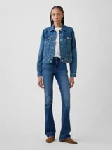 Jean de corte baby boot con tiro medio y lavado azul medio, confeccionado en denim con costuras reforzadas y cierre frontal con botón y cremallera.