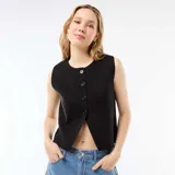 Chaleco sin mangas de color negro, con cuello redondo y cierre frontal mediante botones. Presenta un diseño corto con una abertura en la parte inferior.