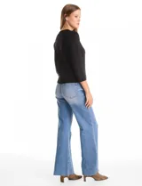 Cardigan de tejido fino en color gris, con cuello redondo, cierre frontal con botones y mangas tres cuartos.