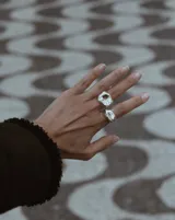 Anillo dorado con forma irregular y un agujero en el centro.