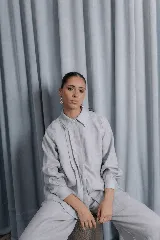 Camisa de lino natural con doble cuello, cartera escondida y dos tablas frontales que aportan movimiento. Presenta mangas largas con puños abotonados y un diseño versátil de corte holgado.