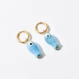Aros dorados tipo argolla con dije colgante de cerámica celeste en forma de pez con ojo.