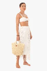 Falda midi de encaje blanco con abertura lateral y flecos en el ruedo.