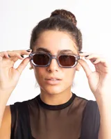 Lentes de sol con marco rectangular transparente azulado y lentes marrones.