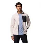 Campera polar de corderito en color beige, con cuello alto, cierre frontal completo y un bolsillo en el pecho de color negro con cierre y etiqueta de la marca. Cuenta con bolsillos laterales y puños con ribete elástico.