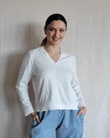 Remera de algodón manga larga con escote en V y detalle de pespuntes en color beige. Presenta un corte recto y costura central vertical en el frente.