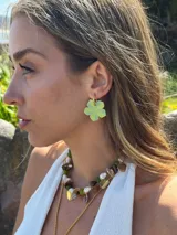 Aro colgante con gancho de acero quirúrgico y dije en forma de flor de cinco pétalos, pintado a mano en tonos verde lima y amarillo.