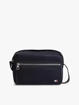 Morral cruzado Tommy Hilfiger de diseño práctico y funcional, confeccionado en poliamida reciclada azul marino con forro de poliéster. Cuenta con un compartimento principal, bolsillo exterior con cierre de cremallera, correa ajustable extraíble y detalles distintivos con la bandera metalizada de la marca.