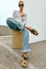 Mocasín de piel con pelo y estampado animal, con detalle de cordones en el empeine y pespuntes decorativos.