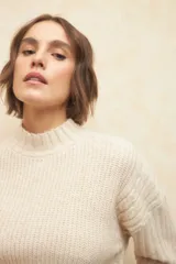 Polera de tejido de punto acanalado color marrón, con cuello alto y mangas largas con puños doblados.