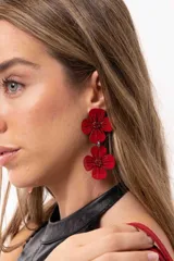 Aros colgantes de diseño floral en color rojo vibrante, compuestos por dos flores superpuestas con acabado brillante y detalles texturizados en el centro.