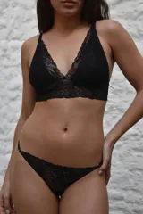 Bralette negro de encaje con diseño largo tipo crop top, sin aro ni relleno, con forro interno en las copas de algodón y tirantes ajustables.