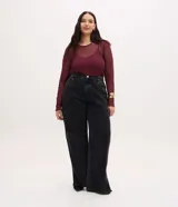 Pantalón wide leg de denim negro con lavado marmorizado, tiro alto, cintura con trabillas, cierre frontal con botón y bolsillos funcionales.