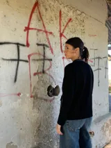 Campera negra de cuero con mangas largas de lana y bolsillos frontales con detalles dorados.