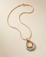 Collar de acero con baño de oro, compuesto por una cadena fina y un dije colgante en forma de lágrima con diseño bicolor en tonos dorado y plateado.