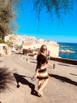 Vestido corto tejido en hilado de algodón con rayas horizontales en negro, tostado y blanco.