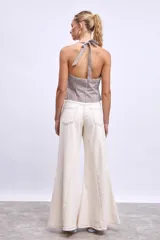 Chaleco con estampado de rayas verticales marrones y blancas, con cuello halter y cierre frontal con botones.