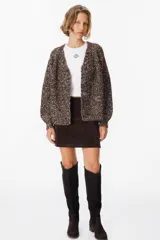 Saco tipo cardigan de tejido de punto con diseño jaspeado en tonos marrón chocolate y crudo. Presenta cuello en V, cierre frontal con botones grandes y mangas largas con hombros caídos.
