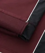 Pantalón de jogging color bordó con paneles laterales en negro y detalles de líneas blancas. Presenta un corte holgado y cintura elástica con cordón de ajuste.