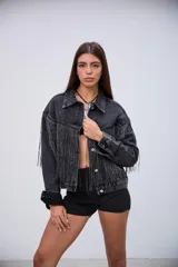 Campera de jean color negro con efecto lavado, de corte oversize, con flecos brillantes integrados en el diseño frontal y en las mangas.