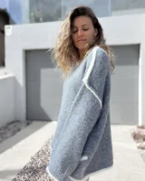 Sweater de tejido de punto en color gris con detalles de bordes en color blanco, de corte holgado y mangas largas.