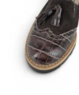 Mocasín tipo Oxford de diseño europeo, confeccionado en una combinación de texturas de cuero que incluye gamuza y cuero con textura croco. Presenta detalles de costuras visibles, elásticos laterales para un calce cómodo y un pequeño taco foliado de 2 cm con suela de goma antideslizante.