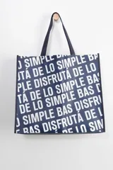 Bolsa reutilizable azul marino con estampado tipográfico en color blanco con la frase 'Disfrutá de lo simple'.