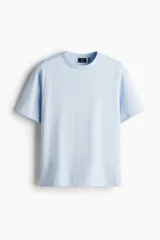 Remera de punto pesado en color celeste, con cuello redondo, hombros caídos y corte holgado. Confeccionada con tecnología de fibra sintética para transporte de humedad.