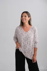 Sweter de punto con diseño amplio, escote en V y mangas largas. Presenta un estampado geométrico tipo mosaico en tonos beige y gris claro.