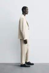 Blazer de corte regular fit confeccionado en tejido con lana. Presenta cuello con solapas de muesca, cierre frontal de un botón, bolsillos de vivo en el pecho y en la cadera, y aberturas en la espalda.