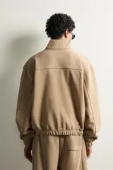 Sudadera regular fit de color beige, confeccionada en tejido con algodón, con cuello subido, cierre frontal de cremallera parcial, manga larga, bolsillo plastrón en el pecho y acabados en rib elástico.