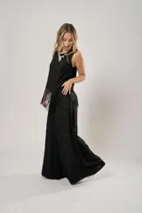 Pantalón negro súper campana de tiro medio en lino con bordados, con bolsillos delanteros y en la espalda. Cierre frontal con cremallera y botón.