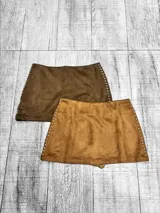 Pollera short de gamuza con detalle de tachas metálicas en los laterales. Diseño de tiro medio con corte ajustado.