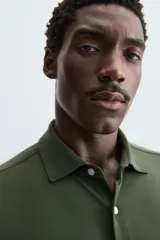 Camisa de manga larga color celeste claro, corte slim fit, con cuello italiano abierto y cierre frontal de botonadura.