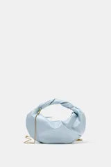 Bolso de mano celeste de diseño fruncido, con asa superior retorcida y cadena metálica dorada estilo bandolera. Cuenta con cierre de cremallera.