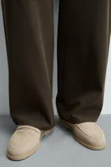 Mocasín casual color beige de piel con acabado serraje, antifaz en el empeine, horma redonda y suela a tono.