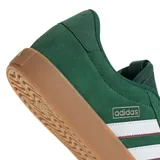 Championes Adidas modelo VL Court 3.0, de color verde con diseño clásico. Presenta la parte superior en gamuza con las icónicas tres tiras laterales en blanco con bordes oscuros. Cuenta con suela de caucho color caramelo y cierre mediante cordones al tono.