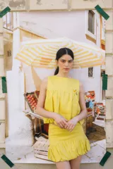 Top musculosa de lino color amarillo, con cuello redondo y diseño estilo balloon con elástico en el bajo. Cuenta con cierre de botones en la parte trasera.