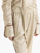 Babucha de corte amplio confeccionada en una mezcla de viscosa y seda con estampado floral pequeño. Presenta cintura elástica, puños ajustados en los tobillos y vivos laterales en contraste.