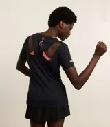 Remera deportiva negra de poliamida con mangas cortas, cuello redondo, textura y recorte cutout en la espalda con inscripción Active en rosa.