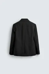 Blazer de corte relajado confeccionada en mezcla de lana y viscosa. Presenta cuello con solapas de muesca, cierre frontal de un botón, bolsillos con solapa en la cadera y abertura central en la espalda. Incluye forro interior a contraste y puños con botones.