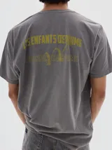 Remera de algodón con efecto lavado, cuello redondo y mangas cortas. Presenta un estampado gráfico en el pecho con la frase 'Les Enfants Deprime'.