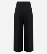 Pantalón de sastrería negro de modelado amplio, con pinzas frontales y cintura con pasadores.
