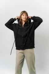 Campera deportiva con capucha de corte oversize, confeccionada en tejido suave con interior forrado en piel sintética. Presenta cierre frontal completo, bolsillos laterales y capucha amplia con cordones largos ajustables.