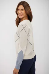 Sweater de punto con cuello en V y diseño de rombos en tonos beige, azul y blanco. Presenta mangas largas con puños ajustados y corte clásico.