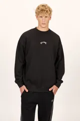 Buzo Billabong Arch Over Crew de color negro, con cuello redondo y diseño de mangas caídas. Presenta un pequeño bordado en hilo blanco en el centro del pecho con el nombre de la marca en tipografía arqueada.